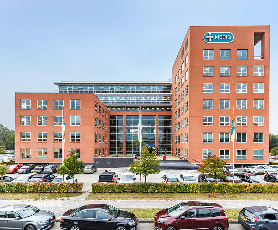 Mediq Group orange main building with cars parked in front of it