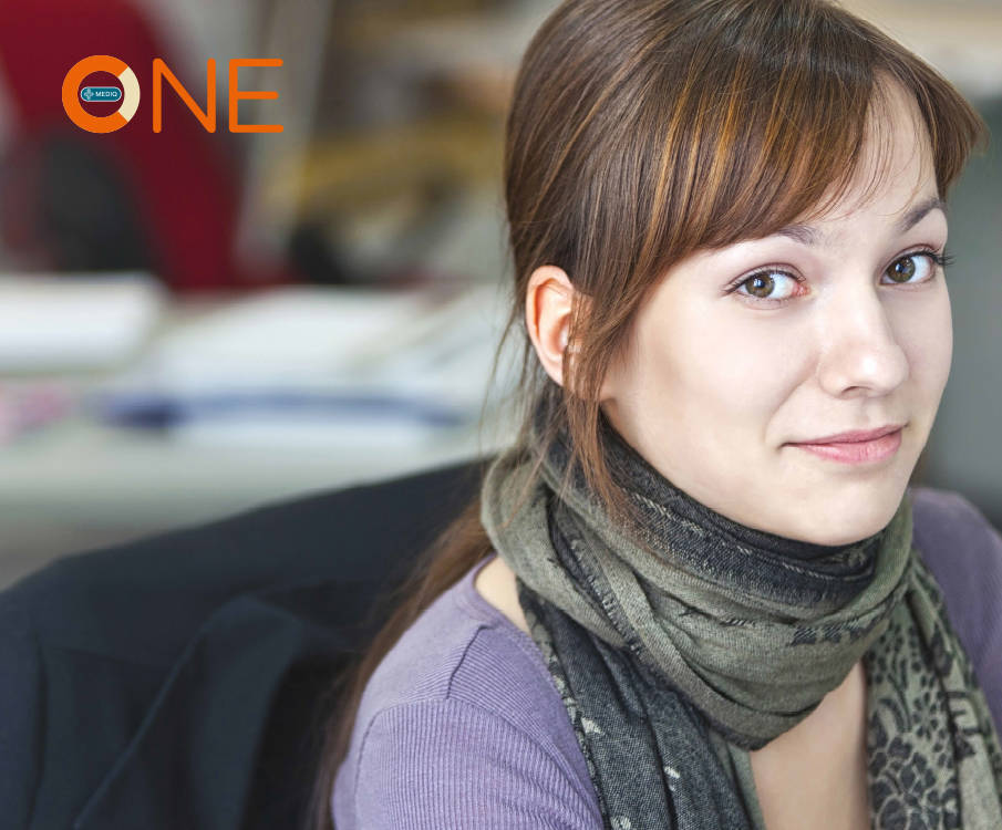 Brown-headed smiling young girl with a scarf in the office